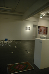 会場風景:手前 田中偉一郎『夢のホールインワン』2006年、バケツ、ティッシュペーパー、点滅するLED、敷物